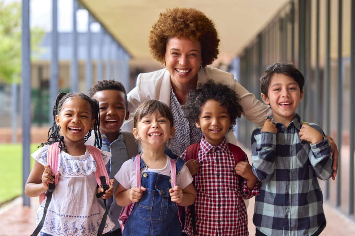 Portrait Of Multi Cultural Elementary School Pupils With Female Teacher Outdoors At School